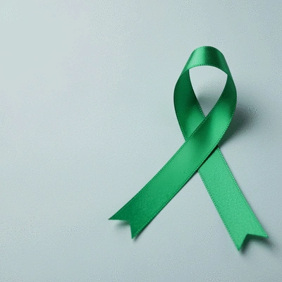 Green ribbon symbolizing mental health awareness, placed on a calm, light background